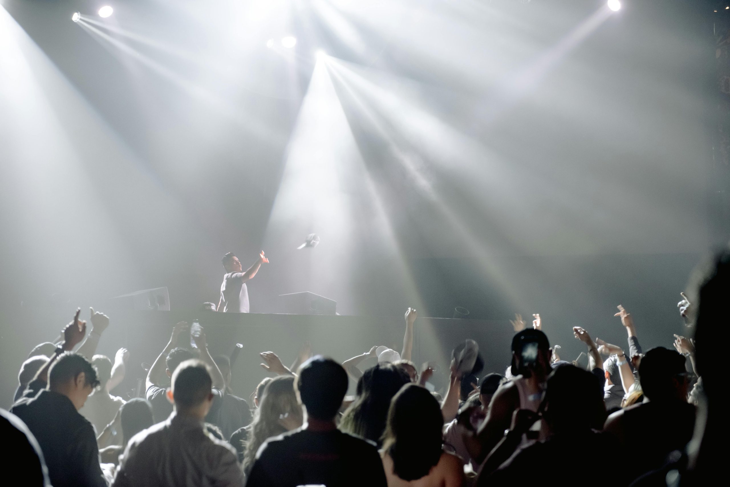 DJ performing in a lively nightclub with a crowd enjoying the vibrant atmosphere.