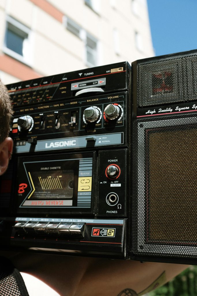 Close-up of a vintage boombox stereo held outdoors, evoking nostalgic music vibes.